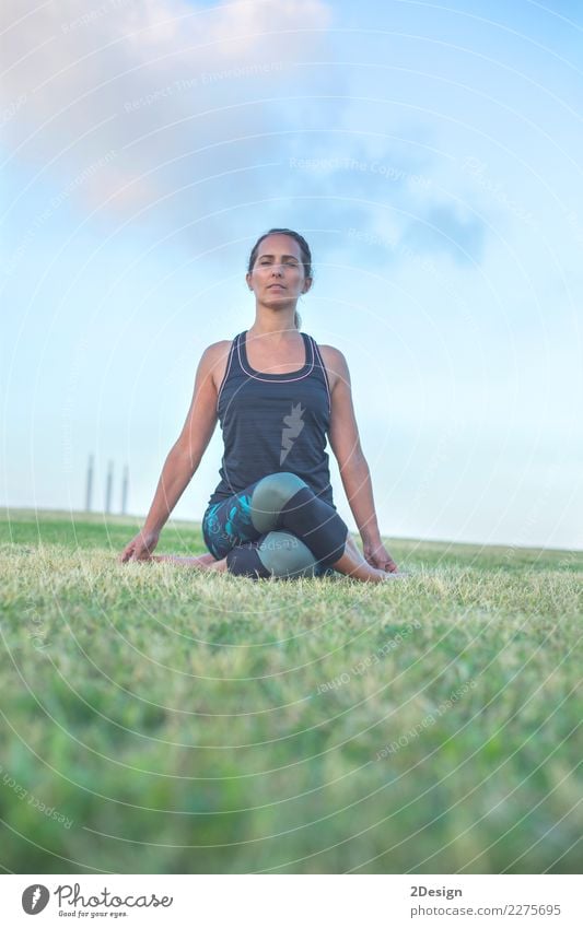 Schönes Mädchen nimmt an Yoga im Park teil Lifestyle harmonisch Erholung Sport Frau Erwachsene Jugendliche Natur Gras sitzen grün Kraft Konzentration