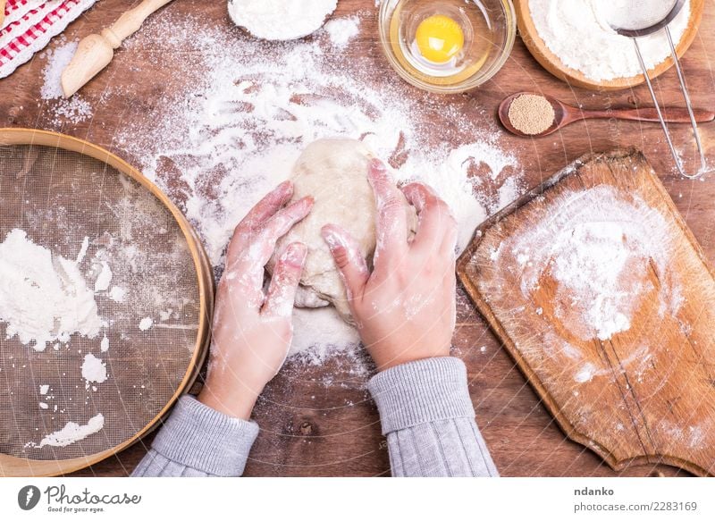 Hände stören einen Ball aus Hefeteig Teigwaren Backwaren Brot Schalen & Schüsseln Löffel Körper Tisch Küche Arme Hand Sieb Holz Essen frisch natürlich oben