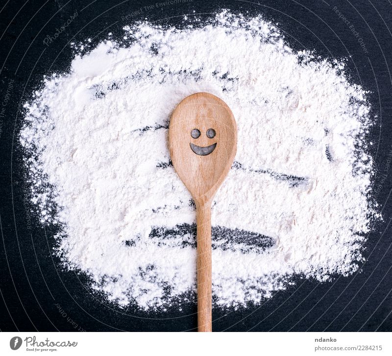 Holzlöffel mit einem geschnitzten lächelnden Gesicht Teigwaren Backwaren Brot Ernährung Löffel Tisch Küche Essen Lächeln natürlich schwarz weiß Koch roh Mehl