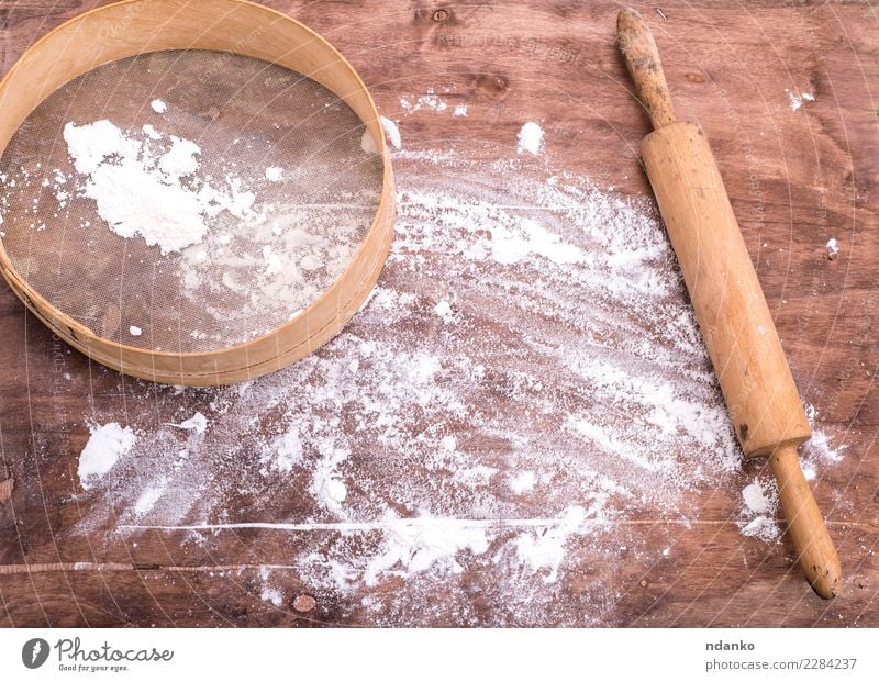 Mehl auf einem braunen Holztisch bestreut Teigwaren Backwaren Brot Tisch Küche Sieb retro weiß Weizen Essen zubereiten kulinarisch backen Raum Holzplatte