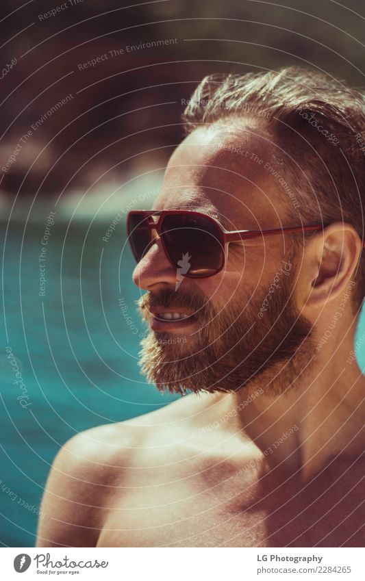 Ein sonniger Tag am Strand Ferien & Urlaub & Reisen Meer Fotokamera Mensch Mann Erwachsene Bekleidung Sonnenbrille Vollbart Lächeln stehen Fröhlichkeit braun