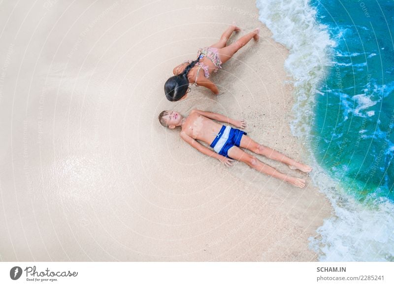 Netter Junge und Mädchen, die Spaß auf dem sonnigen tropischen Strand hat. Lifestyle Freude Glück Freiheit Sommer Sommerurlaub Sonne Sonnenbad Meer Insel Wellen