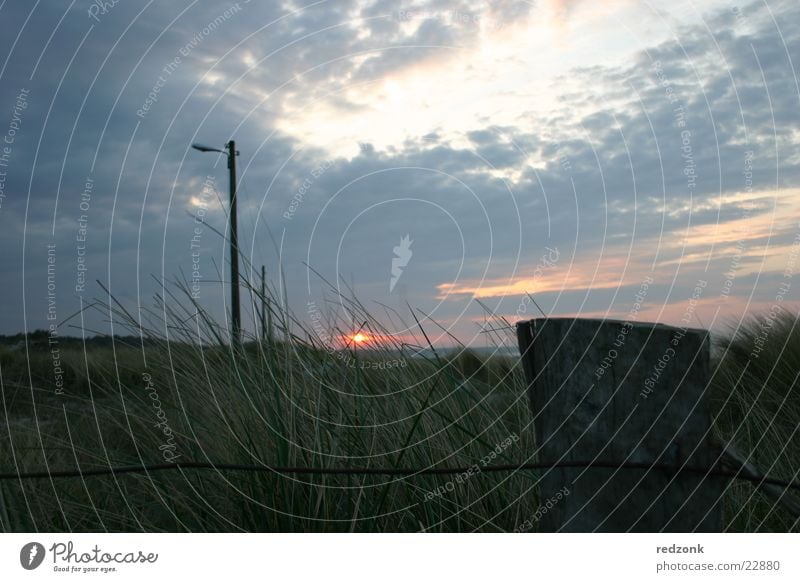 Dünen im Abendrot II Sonnenuntergang Zaun Wiese Gras Hügel Meer Wolken dunkel Stranddüne Strommast Beleuchtung