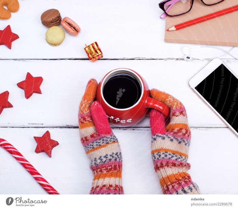 Hände in gestrickten Handschuhen halten eine rote Tasse Lebensmittel Kaffee Körper Winter Tisch Feste & Feiern Weihnachten & Advent Telefon PDA Frau Erwachsene