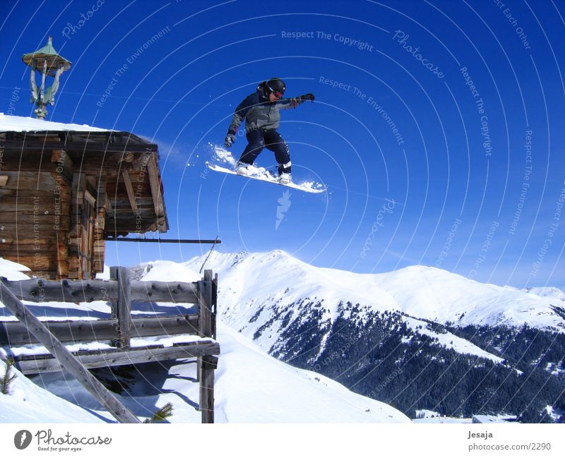 Snowboardsprung springen Panorama (Aussicht) Zell am Ziller Extremsport Hütte Schanze gerlos groß Dach Blauer Himmel Mut gewagt 1 Snowboarder Snowboarding