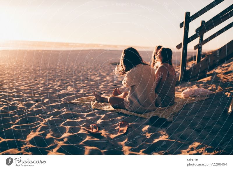 Gruppe Freunde, die auf dem Strand sitzen und Sonnenuntergang genießen Glück Erholung Freizeit & Hobby Ferien & Urlaub & Reisen Party feminin Freundschaft