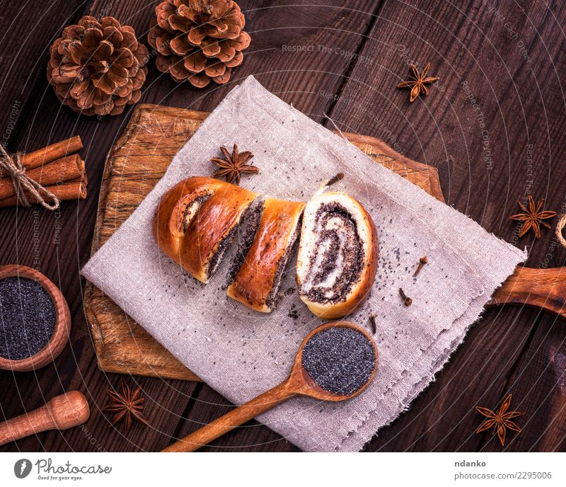 geschnittene Mohnrollen Lebensmittel Brot Brötchen Dessert Süßwaren Löffel Tisch Holz Essen frisch lecker oben braun Tradition Samen Biskuit Schneidebrett