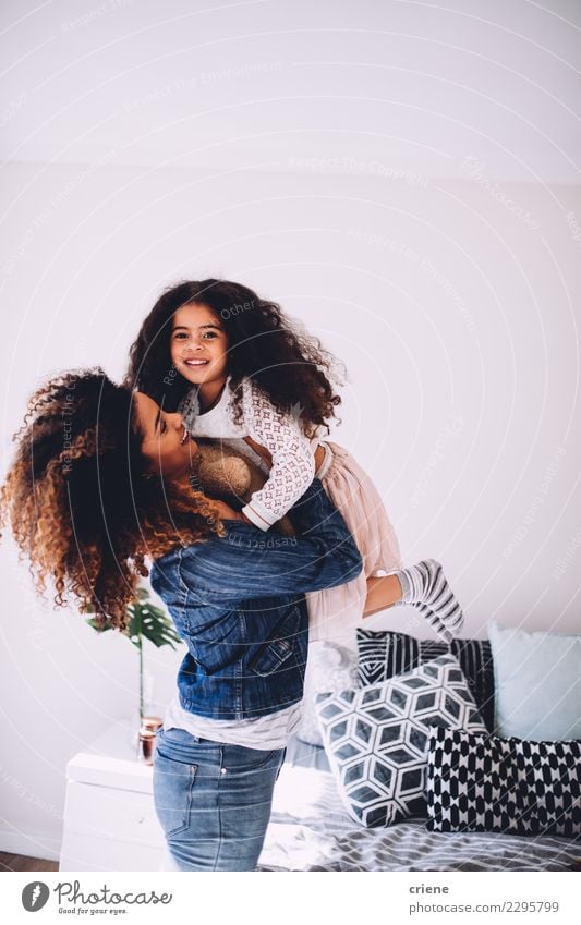 Eine Mutter, die ihre kleine Tochter hält und schwingt. Freude Glück schön Spielen Haus Schlafzimmer Kindererziehung Eltern Erwachsene Familie & Verwandtschaft