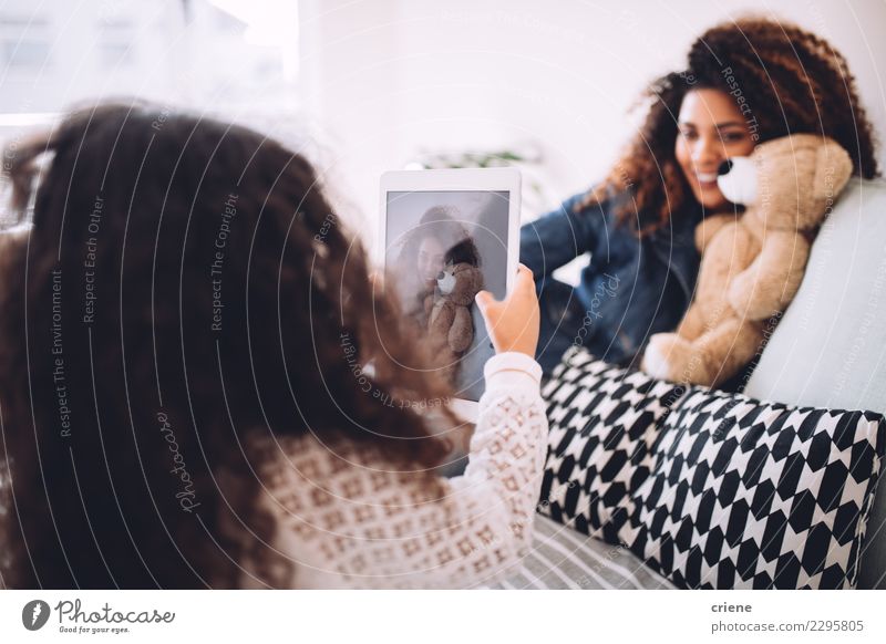 Kleines Mädchen beim Fotografieren mit der Tafel ihrer Mutter Lifestyle Freude Glück schön Kind Telefon Frau Erwachsene Eltern Familie & Verwandtschaft Lächeln