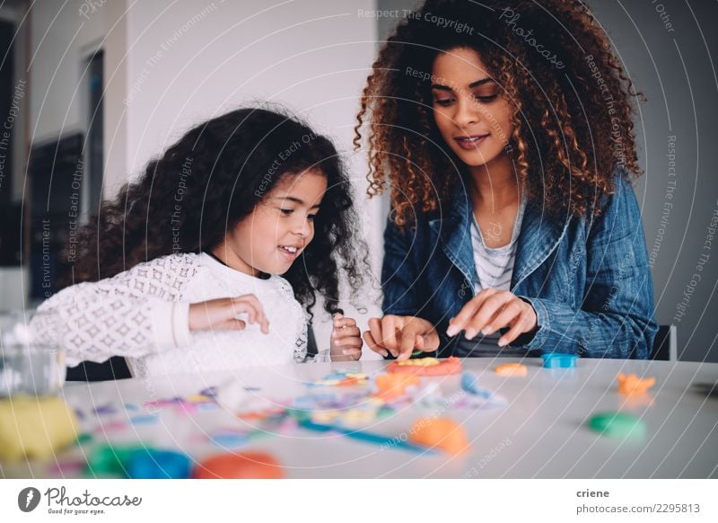 Afrikanische Mutter und Tochter, die zusammen mit Spielwaren spielen Freude Glück Spielen Tisch Kindergarten Schule Frau Erwachsene Eltern