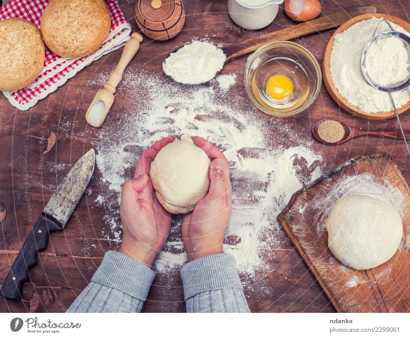 Hände halten einen Ball aus Hefeteig Teigwaren Backwaren Brot Schalen & Schüsseln Messer Körper Tisch Küche Arme Hand Sieb Holz frisch natürlich oben braun weiß