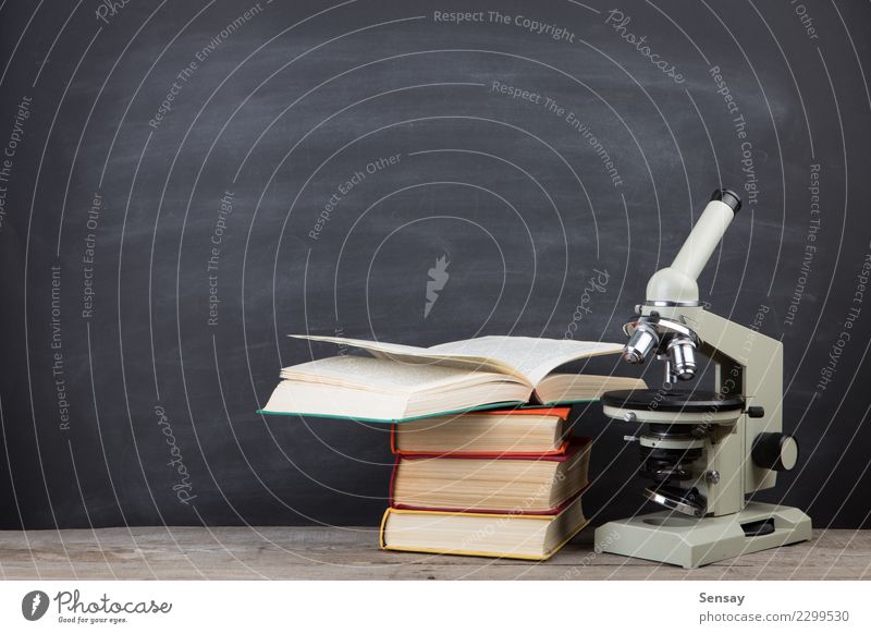 Bildungskonzeptbücher auf dem Schreibtisch im Auditorium Tisch Wissenschaften Schule lernen Klassenraum Tafel Studium Labor Buch Bibliothek Mikroskop schreiben