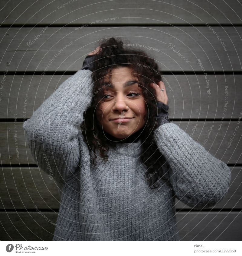 Nikolija feminin Frau Erwachsene 1 Mensch Mauer Wand Pullover brünett langhaarig Locken beobachten festhalten Blick außergewöhnlich dunkel Freundlichkeit schön