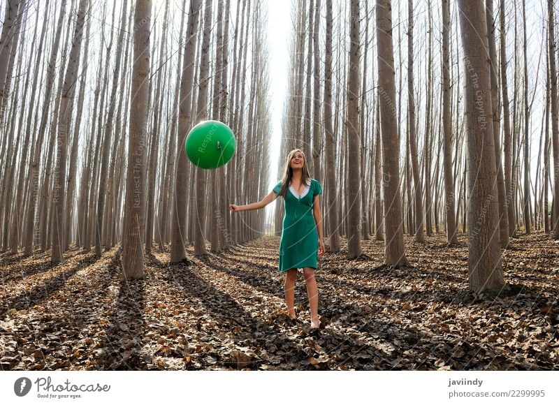 Junge Frau im Pappelwald mit grünem Kleid und Ballon Lifestyle Freude schön Mensch Jugendliche Erwachsene 1 18-30 Jahre Natur Herbst Baum Blatt Park Wald blond