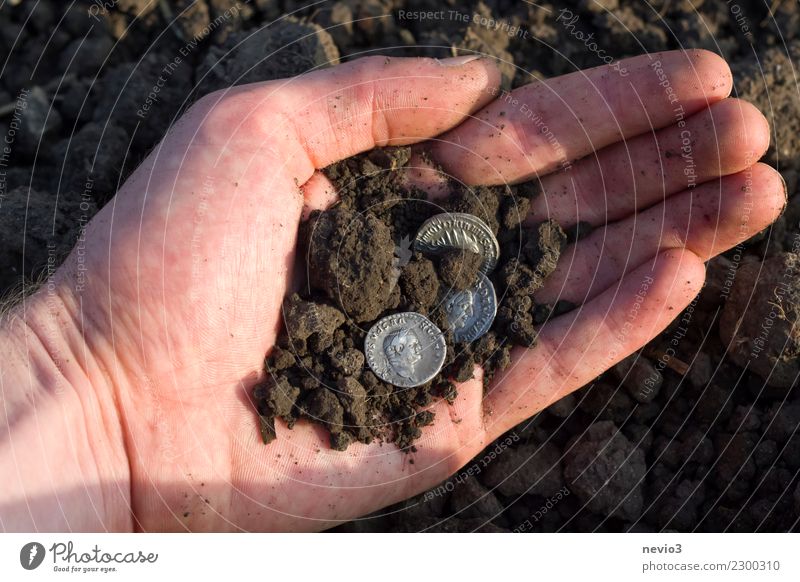 Römische Silbermünzen (Denare) in einer Hand Business dreckig dunkel authentisch historisch rund silber Römische Münze Caesar Römische Münzen Rom Fund Fundstück