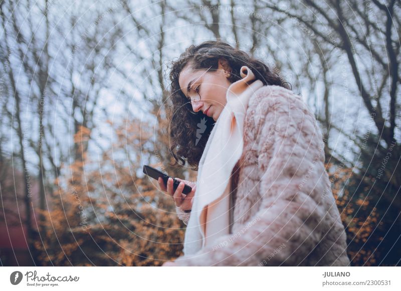 Junge stilvolle Frau, die ihren Smartphone betrachtet Lifestyle kaufen elegant Stil schön Freizeit & Hobby Städtereise Winter Winterurlaub Mensch Frühling