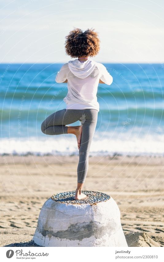 Hintere Ansicht der jungen schwarzen Frau, die Yoga im Strand tut Lifestyle Haare & Frisuren Wellness Erholung Meditation Freizeit & Hobby Sport Mensch