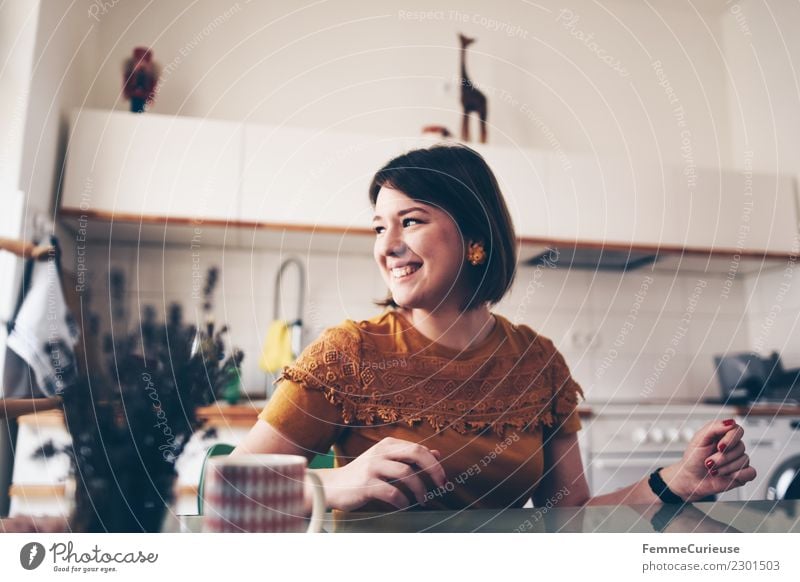 Young brunette woman sitting in a kitchen Lifestyle elegant Stil feminin Junge Frau Jugendliche Erwachsene 1 Mensch 18-30 Jahre schön Häusliches Leben Glück