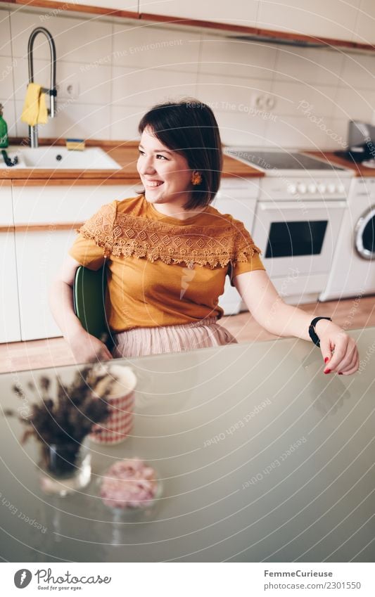 Young woman sitting in her kitchen feminin Junge Frau Jugendliche Erwachsene 1 Mensch 18-30 Jahre Häusliches Leben Zufriedenheit Küche Küchentisch Haus