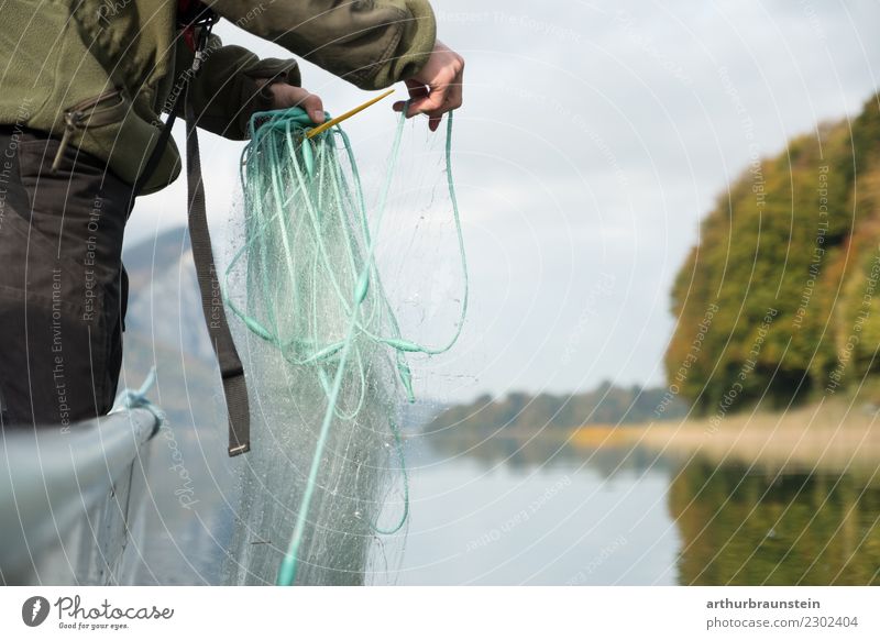 Fischer auf Fischerboot am See legt Fischernetz aus Lebensmittel Ernährung Gesunde Ernährung Freizeit & Hobby Angeln Arbeit & Erwerbstätigkeit Beruf