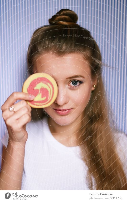 Young woman holding a cookie in front of her face feminin Junge Frau Jugendliche Erwachsene 1 Mensch 18-30 Jahre genießen Keks Mürbeplätzchen Backwaren Süßwaren