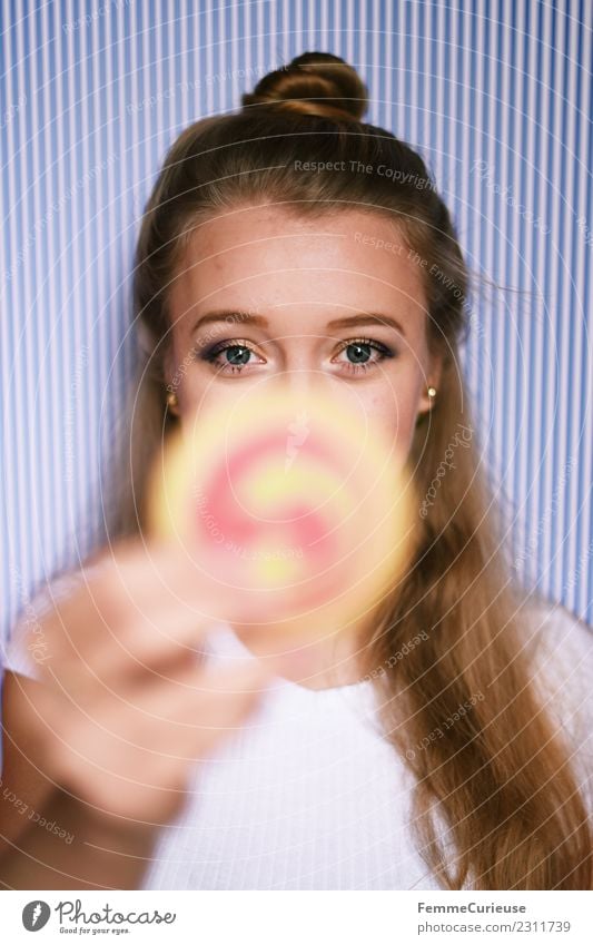 Young blonde girl holding a cookie in her hand feminin Junge Frau Jugendliche Erwachsene 1 Mensch 18-30 Jahre Freude Keks Süßwaren Backwaren hochhalten Dutt