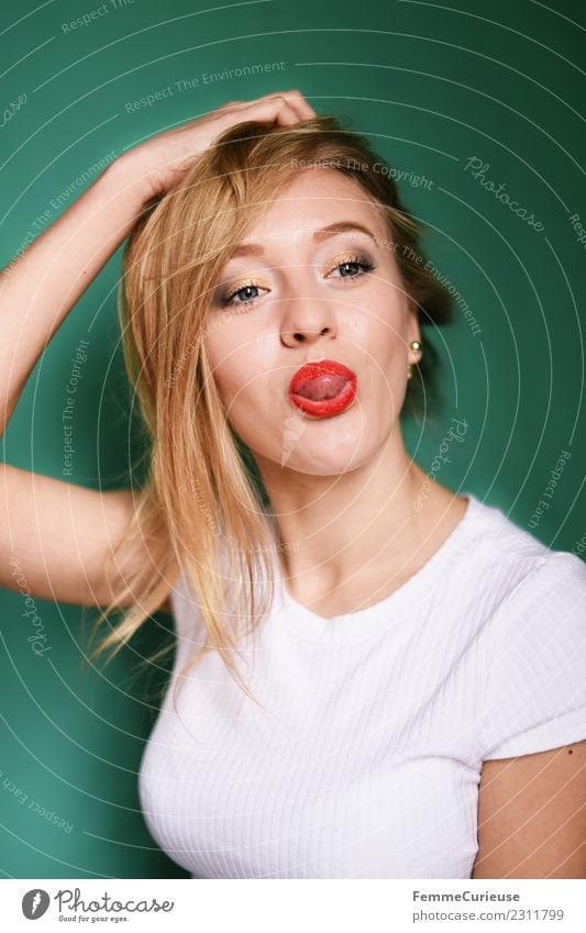 Happy girl stretching out tongue feminin Junge Frau Jugendliche Erwachsene 1 Mensch 18-30 Jahre Freude türkis blond Zunge rausstrecken Lippenstift