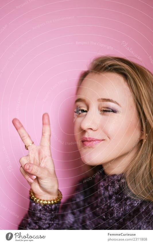 Young blonde woman showing the peace sign feminin Junge Frau Jugendliche Erwachsene 1 Mensch 18-30 Jahre Frieden schön Peace-Zeichen Hand gestikulieren Zwinkern