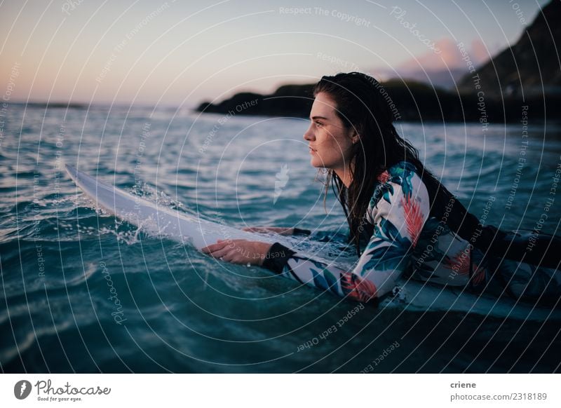 Junge Frau, die auf dem Surfbrett im Wasser liegt. Lifestyle Freude Glück schön Freizeit & Hobby Ferien & Urlaub & Reisen Sommer Sonne Strand Meer Wellen Sport