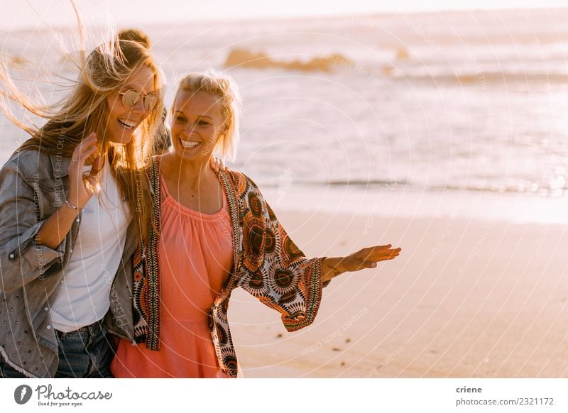 Zwei junge erwachsene Freundinnen, die am Strand plaudern und lachen. Lifestyle Freude Glück schön Ferien & Urlaub & Reisen Sommer Sonne Wellen Frau Erwachsene