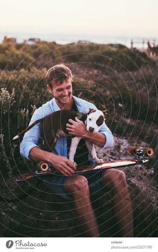 Lächelnder junger Erwachsener mit süßem Welpen auf Skateboard Freude Glück Spielen Sommer Frau Familie & Verwandtschaft Freundschaft Tier Haustier Hund Liebe