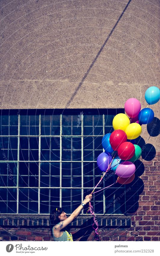 nach rechts oben Frau Erwachsene 1 Mensch 30-45 Jahre Sonnenlicht Schönes Wetter Industrieanlage Fabrik Fassade Fenster festhalten mehrfarbig Luftballon