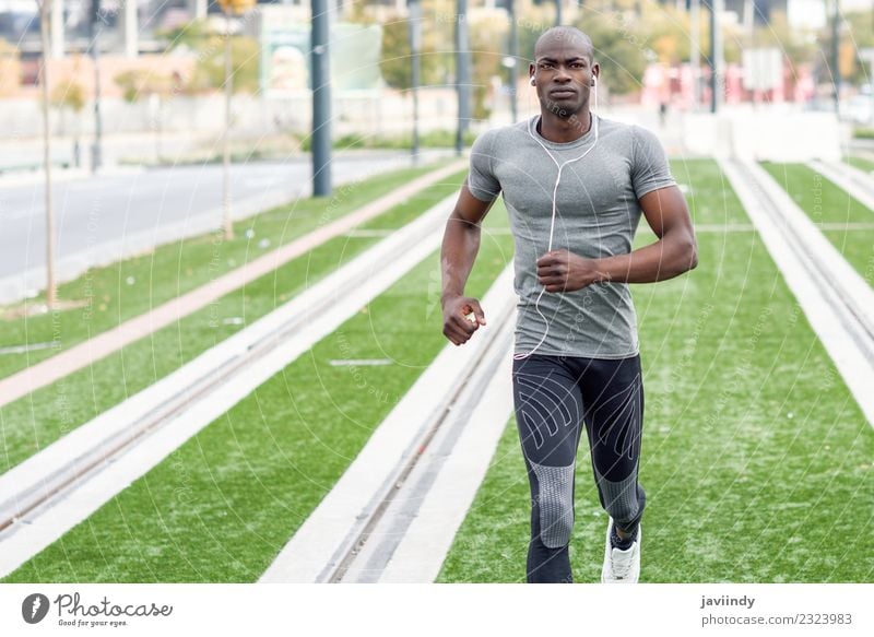 Schwarzer Mann, der im urbanen Hintergrund läuft und Musik hört. Lifestyle Körper Sport Joggen Headset Mensch maskulin Junger Mann Jugendliche Erwachsene 1