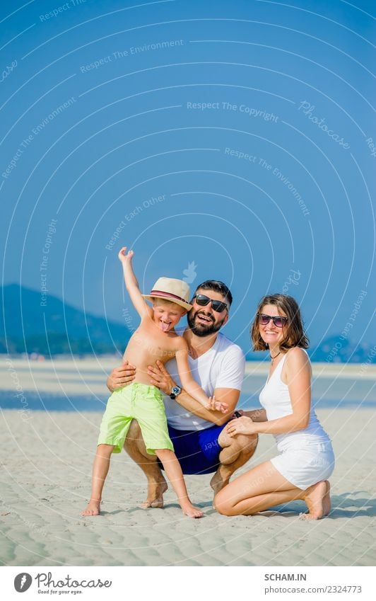 Glückliche junge dreiköpfige Familie, die Spaß am sonnigen Wüstenstrand hat. Lifestyle Freude Spielen Sommer Meer Insel Mensch maskulin feminin Kind Junge Frau