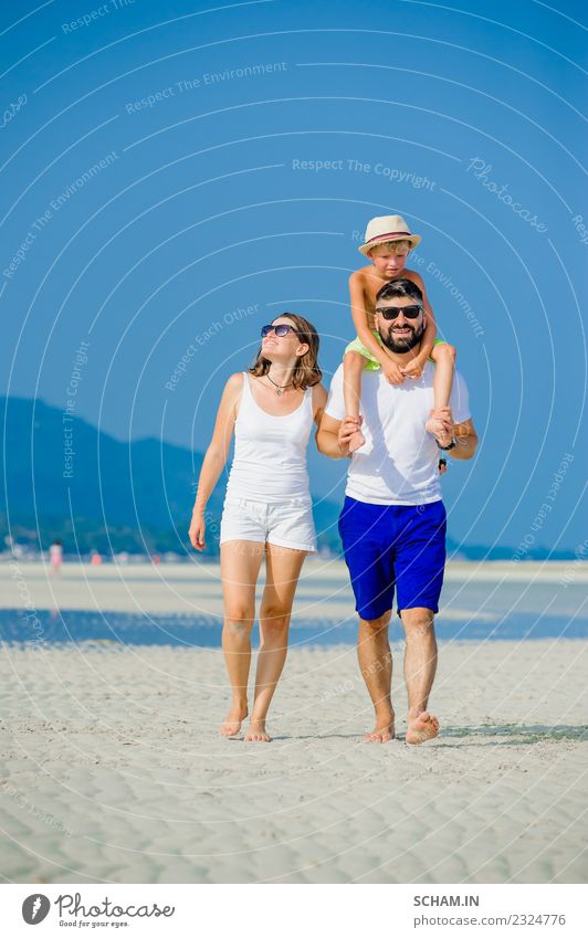 Glückliche junge Dreierfamilie Lifestyle Freude Spielen Sommer Meer Insel Kindheit Menschengruppe Sonnenbrille Vollbart Lächeln Fröhlichkeit Zusammensein