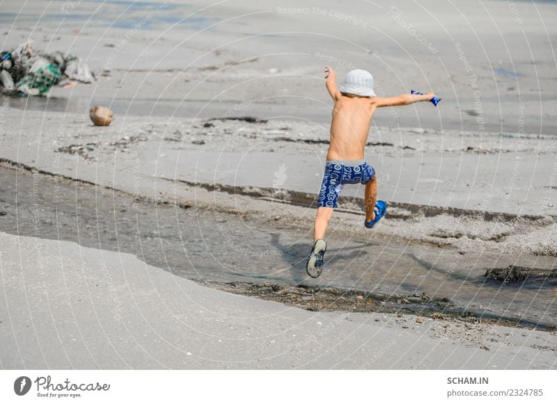 Siebenjähriger Junge, der über den kleinen Fluss springt. Lifestyle Freude Spielen Sommer Meer Insel Mensch Kind Kindheit 1 3-8 Jahre Landschaft Hut Lächeln