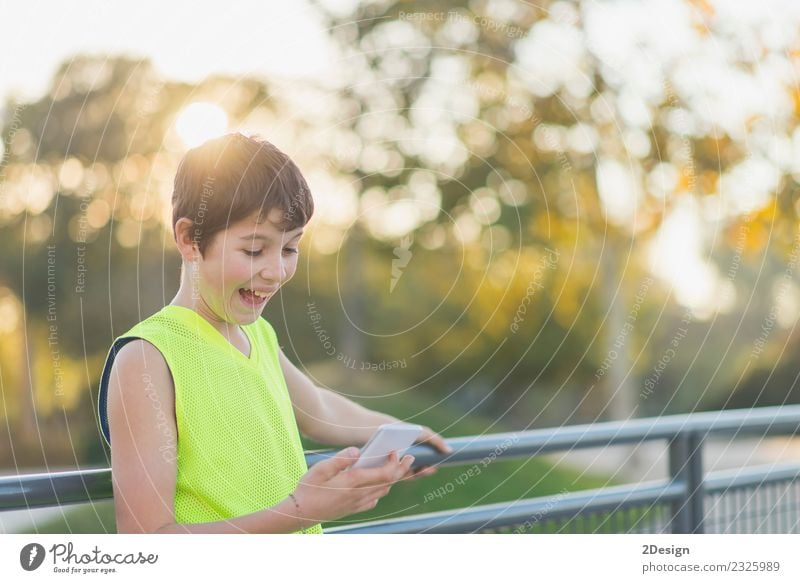 Porträt eines lächelnden Teenagers, der auf seinem Smartphone aussieht. Lifestyle Stil Freude Glück Freizeit & Hobby Dekoration & Verzierung Schule Studium