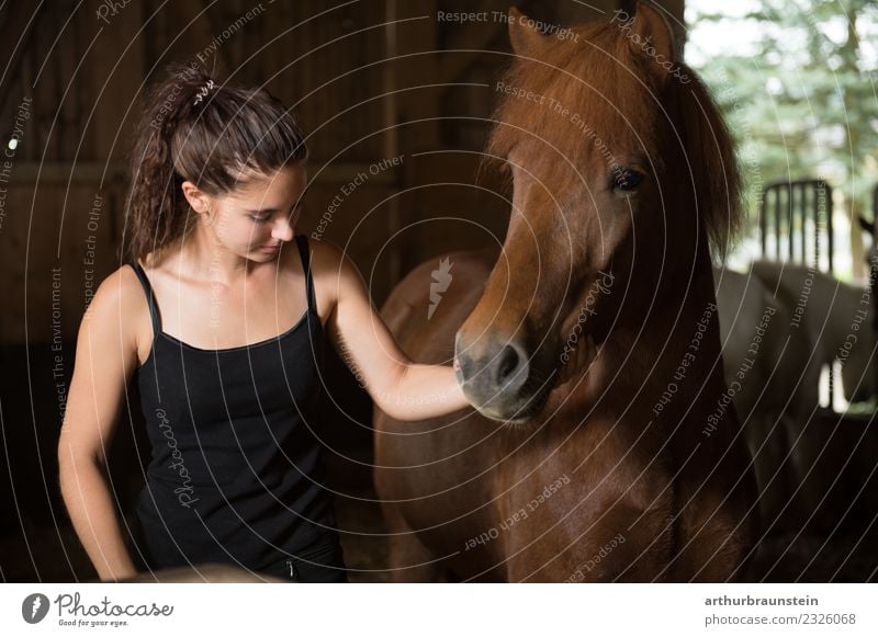 Junge dunkelhaarige lockige Frau mit Pferd im Stall Freizeit & Hobby Reiten Reitsport Reitschule Ferien & Urlaub & Reisen Ausflug Reiterhof Reithalle Mensch