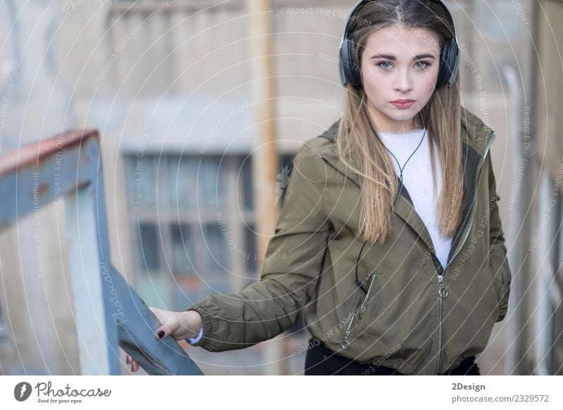 Junge Teenager stehen und Musik hören im Freien Lifestyle Glück Zufriedenheit Haus Schule Headset Fotokamera Technik & Technologie Mensch Frau Erwachsene