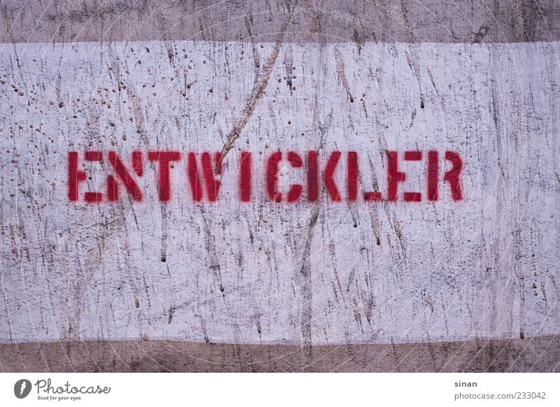 ENTWICKLER Stein Beton Schriftzeichen Schilder & Markierungen Graffiti alt retro grau rot Beschriftung entwickler Schablonenschrift Wand Fotografie Farbfoto