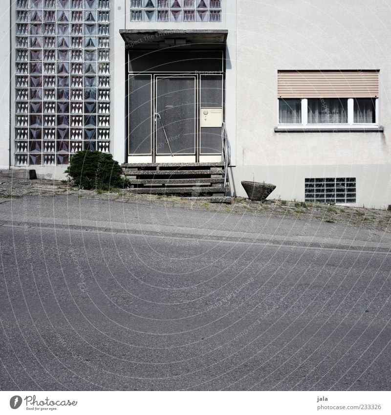 eingang Pflanze Haus Bauwerk Gebäude Architektur Treppe Fassade Fenster Tür Rollladen Glasbaustein Straße Wege & Pfade Bürgersteig trist grau weiß Farbfoto