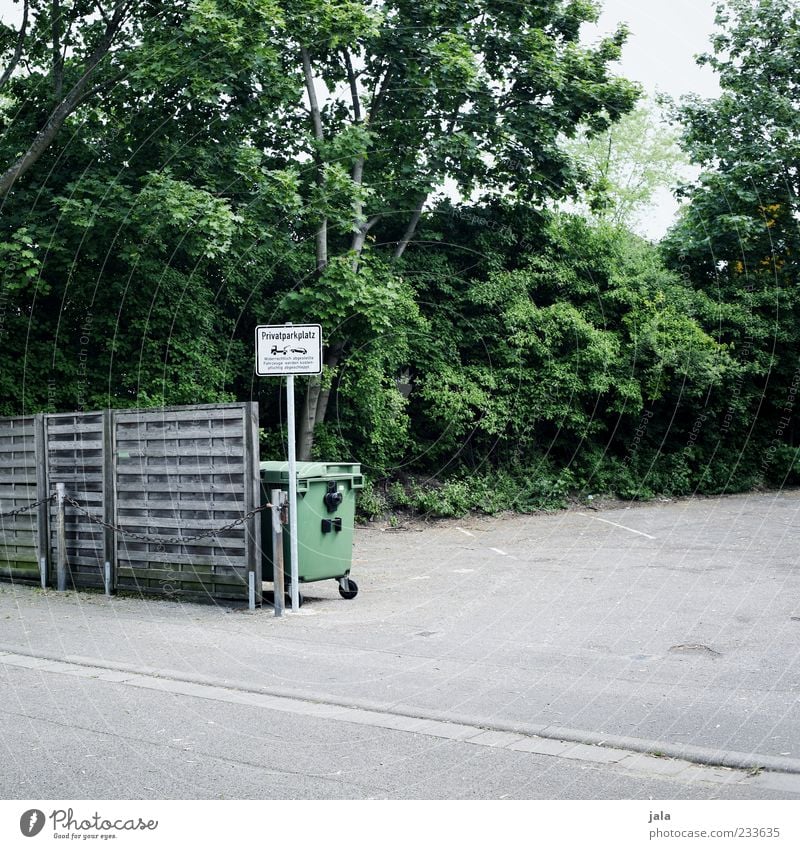 privatparkplatz Natur Pflanze Baum Sträucher Platz Parkplatz Holzzaun Müllbehälter Schilder & Markierungen Hinweisschild Warnschild trist Farbfoto Außenaufnahme