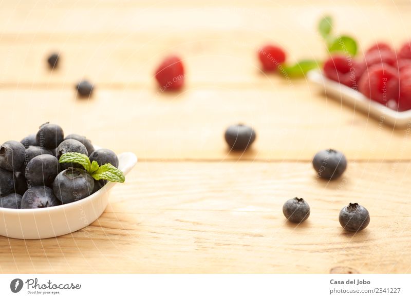 frische und rohe Heidelbeeren und Himbeeren auf Holzgrund Lebensmittel Frucht Dessert Ernährung Essen Frühstück Vegetarische Ernährung Diät Teller