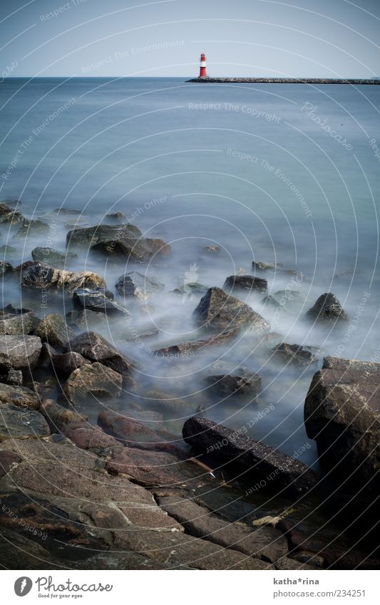 Leuchtturm Landschaft Wasser Felsen Wellen Küste Bucht Ostsee dunkel kalt blau rot weiß Stimmung geduldig ruhig Neugier Sehnsucht Einsamkeit Zufriedenheit