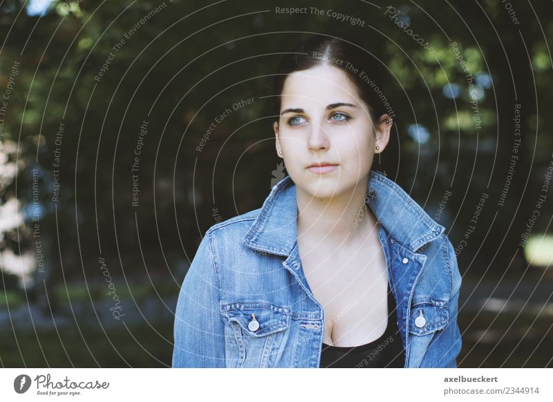 Portrait eines weiblichen Teenagers im Park Junge Frau Jugendliche Lifestyle Jeansjacke Tagträumer Natur Mensch feminin Erwachsene Baum ernst nachdenklich