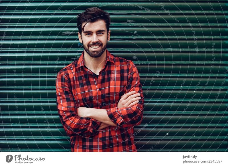 Junger lächelnder Mann, Model der Mode, trägt ein kariertes Hemd mit einer grünen Jalousie hinter sich Lifestyle Stil schön Haare & Frisuren Mensch maskulin