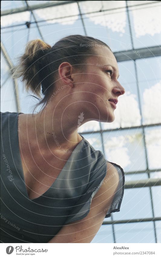 analoges Portrait einer jungen Frau, die in einem Glas- Gewächshaus steht schön Leben Sinnesorgane Himmel Schnee Fenster Junge Frau Jugendliche Gesicht