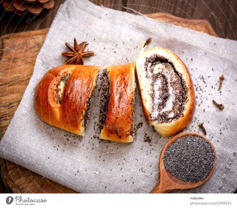 gebackenes Brötchen mit Mohn Brot Dessert Löffel Tisch Holz Essen frisch lecker oben braun Tradition rollen Biskuit Schneidebrett gebastelt geschnitten rustikal