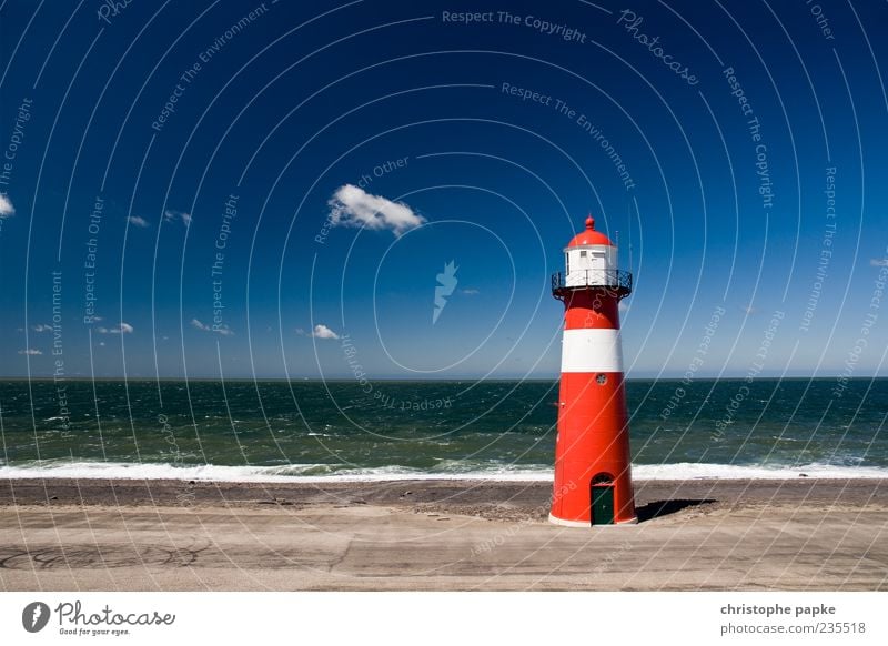 Rot-weiß gestreifter Leuchtturm vor blauem Himmel am Meer Freiheit Sommer Wellen Bauwerk Gebäude Nordseeküste Küste Sehenswürdigkeit Wahrzeichen Schifffahrt