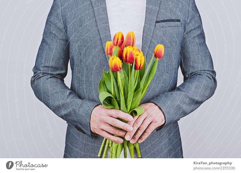 Mann in blauer Jacke mit Tulpenstrauß Glück schön Flirten Feste & Feiern Valentinstag Mensch Erwachsene Mutter Blume Vollbart Blumenstrauß Liebe gelb rot weiß